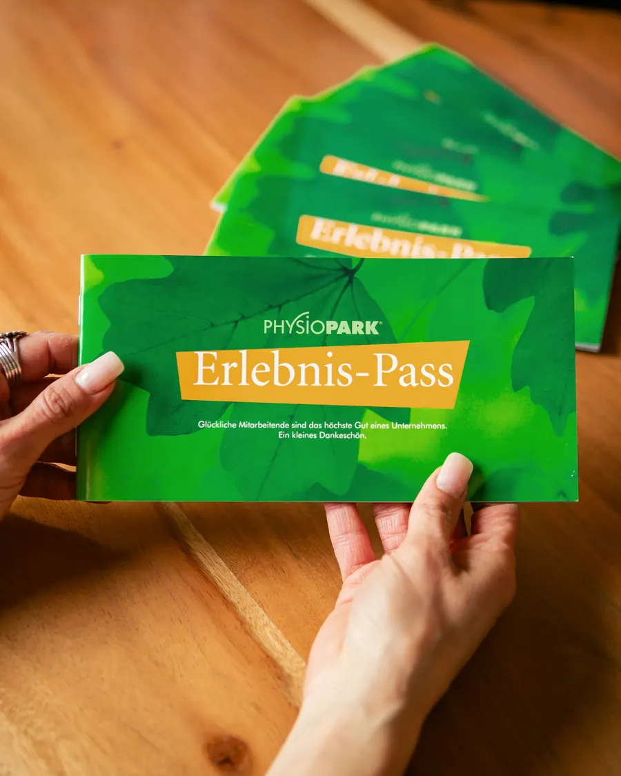 Zwei Hände halten den PHYSIOPARK-Erlebnis-Pass